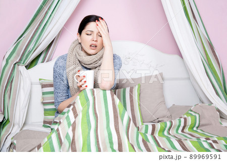Young beautiful sick woman feeling ill and bad lying on bed suffering headache and temperature trying to rest and sleep on bed. 89969591