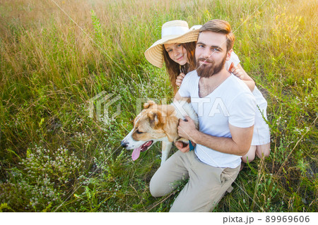 Happy beautiful couple with their Alabai dog in nature with sunset. 89969606