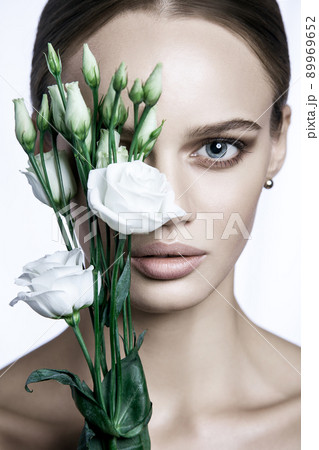 portrait of beautiful model with good skin on white background with white roses flower. 89969652
