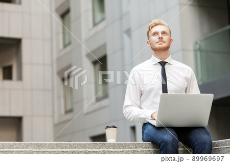 Imagination and dreaming concept. Young adult businessman working outsourcing and wondering . Outdoor Imagination and dreaming concept. Young adult businessman working outsourcing and wondering . Outdoor 89969697