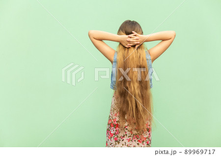 Back side. Beautiful young blonde with long hair, crossed hands onder head. Indoor studio shoot 89969717