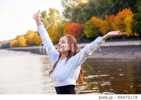Freedom. Young pretty woman at the autumn park near lake. Outdoor shot Freedom. Young pretty woman at the autumn park near lake. Outdoor shot 89970178