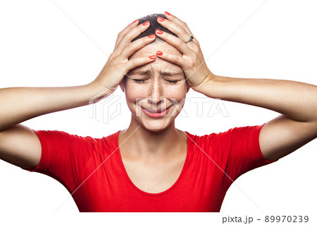Portrait of sad unhappy crying woman in red t-shirt with freckles. closed eyes hands on head, studio shot. isolated on white background. Portrait of sad unhappy crying woman in red t-shirt with freckles. closed eyes hands on head, studio shot. isolated on white background. 89970239