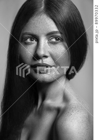 Beautiful fashion model with freckles, makeup and dark hairstyle. .Black and white photography. 89970332