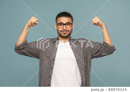 Portrait of bearded strong pride handsome man with black glasses in casual style looking at camera and smiling. studio shot on blue background. 89970334