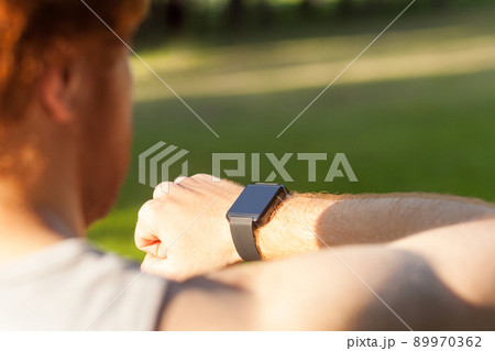 Redhead athlete, watching in smart wath or fitness tracker. Summer, morning, outdoor Redhead athlete, watching in smart wath or fitness tracker. Summer, morning, outdoor 89970362