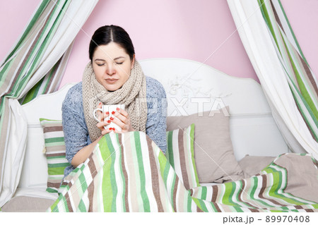 Young beautiful sick woman feeling ill and bad lying on bed suffering headache and temperature trying to rest and sleep on bed. 89970408