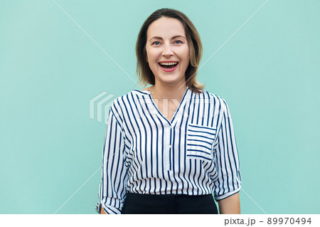 Happiness adult success businesswoman, looking at camera and toothy smile. Outdoor shot in summer. Light blue background 89970494