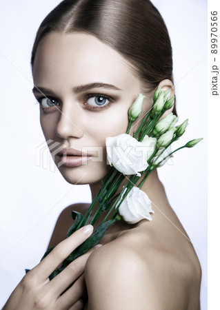 portrait of beautiful model with good skin on white background with white roses flower. portrait of beautiful model with good skin on white background with white roses flower. 89970566