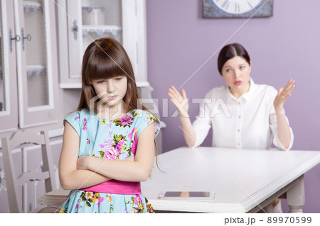 Mother and daughter quarrel because of overuse the tablet phone. Social problem between parents and children. Studio shot.. 89970599