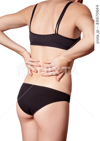 Closeup view of a young woman with pain in back on white background. Closeup view of a young woman with pain in back on white background. 89970664