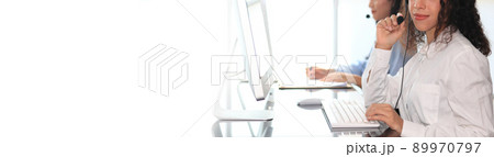 Call center agent with headset working on support hotline in modern office with copy space. Call center agent with headset working on support hotline in modern office with copy space. 89970797