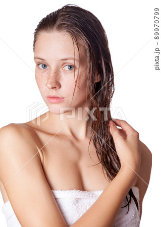 Portrait of a beautiful model with wet hair and clean skin and freckles after shower isolated on white background. 89970799