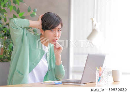 頭を抱え顔を上げた女性1 89970820