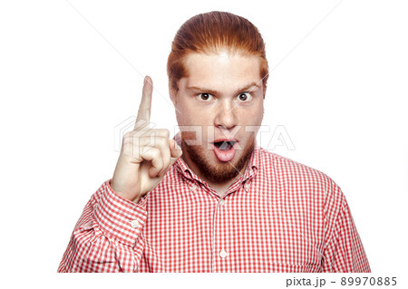 Excited man pointing a great idea, happy bearded readhead businessman with red shirt and freckles looking at camera. studio shot isolated on white.. 89970885