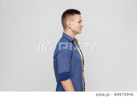 Profile young boy. Standing near gray wall 89970946