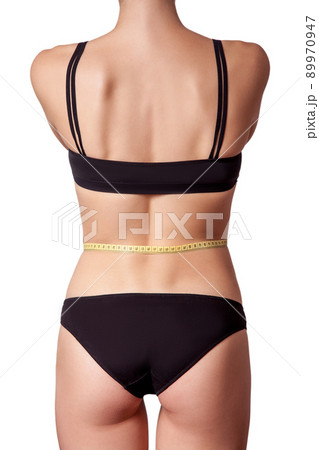 Slim fit happy young woman with measure tape measuring her waist with black underwear, isolated on white background. studio shot. Slim fit happy young woman with measure tape measuring her waist with black underwear, isolated on white background. studio shot. 89970947