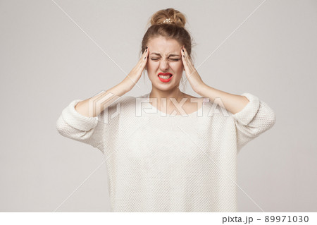 Pain concept, bad feelings. Blonde woman have a migraine and headache. Studio shot Pain concept, bad feelings. Blonde woman have a migraine and headache. Studio shot 89971030
