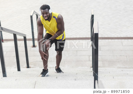 Closeup portrait unhappy man. Problems with joints in athletes after jogging. Outdoor shot, morning. Spring or summer 89971850