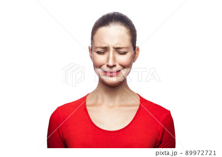 Portrait of sad unhappy crying woman in red t-shirt with freckles. closed eyes, studio shot. isolated on white background. Portrait of sad unhappy crying woman in red t-shirt with freckles. closed eyes, studio shot. isolated on white background. 89972721