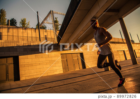 Aged sportsman running on country road, healthy inspirational fitness lifestyle, sport motivation speed interval training. Runner jogging training and doing workout exercising power walking outdoors 89972826