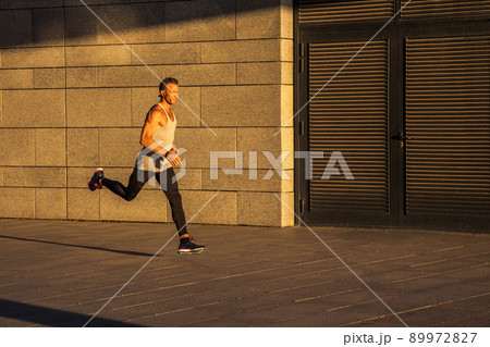 Aged sportsman running on country road, healthy inspirational fitness lifestyle, sport motivation speed interval training. Runner jogging training and doing workout exercising power walking outdoors 89972827