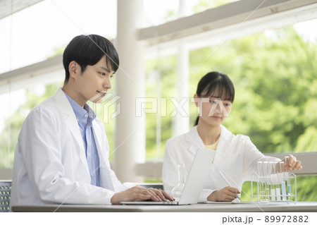 実験をする白衣を着た若い男女 89972882