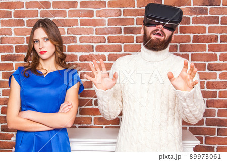 VR technology and conflict between couple. man using vr headset and his wife is angry. 89973061
