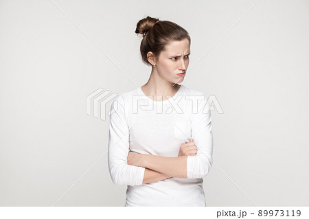 Irritation girl. Young adult woman crossed hands and looking away. Indoor shot Irritation girl. Young adult woman crossed hands and looking away. Indoor shot 89973119