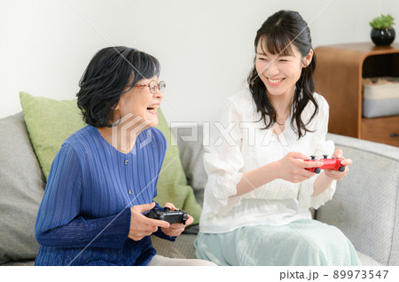 ゲームを一緒にやって微笑む高齢者と家族 ゲームを一緒にやって微笑む高齢者と家族 89973547