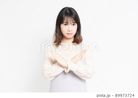 白い背景の前でNGのポーズをする若い女性 白い背景の前でNGのポーズをする若い女性 89973724