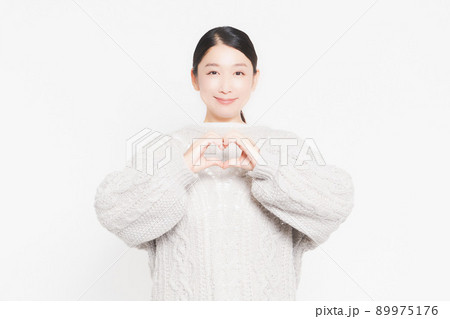 手でハートの形を作って見せている主婦 89975176