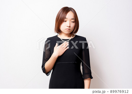 胸に手を当てている喪服を着ている女性 胸に手を当てている喪服を着ている女性 89976912