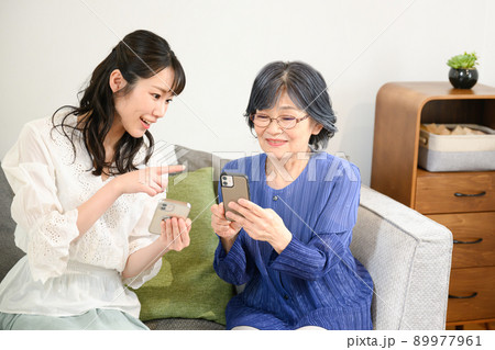 スマホを教えてもらうおばあちゃん 89977961