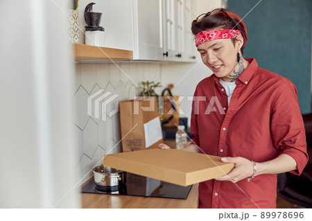 Happy Asian man holding paper pizza box with home delivery 89978696