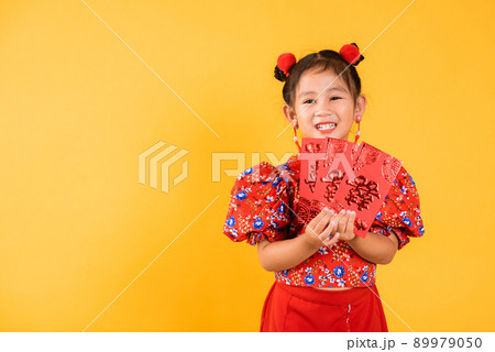 Happy Asian Chinese little girl smile wear red cheongsam qipao hold angpao red packet monetary gift 89979050