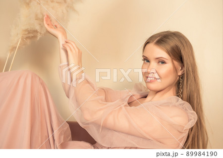girl in pastel-colored dress sits on chair with her legs up girl in pastel-colored dress sits on chair with her legs up 89984190