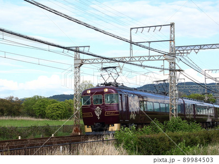 世界遺産の奈良平城宮跡内を走行する近鉄の観光特急「あをによし」 89984503