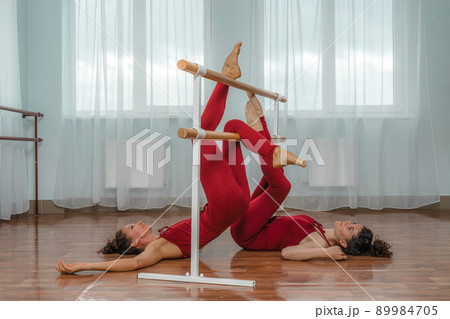 I train with a friend. Two young women train together in a bright training room near a choreographic machine. 89984705