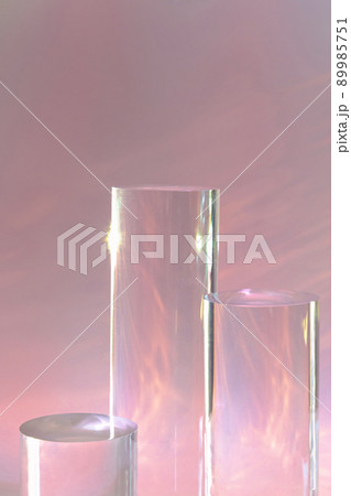 three clear glass cylinder podiums on pastel pink background three clear glass cylinder podiums on pastel pink background 89985751