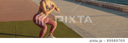 Healthy adult female exercising by the waterfront Healthy adult female exercising by the waterfront 89989769