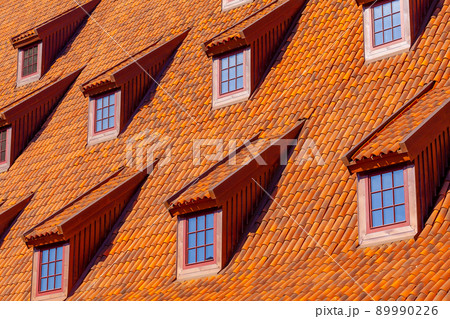Many small windows on a red roof covered with tiles in the old town of Gdansk Many small windows on a red roof covered with tiles in the old town of Gdansk 89990226