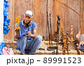 old afro american street artist showing his wooden sculpture 89991523