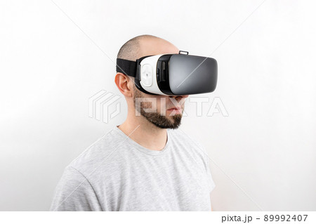 Portrait of a Caucasian man in VR glasses on a white background. The concept of virtual reality and modern entertainment 89992407