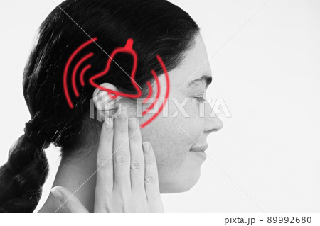 Tinnitus. A dissatisfied young woman holds her hand over her ears, experiencing ringing and pain. The concept of ear diseases and deafness 89992680