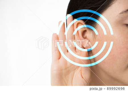 Hearing test. A young woman holds her hand to her ear, close-up. Isolated on a white background. Copy space. The concept of hearing health and deafness 89992696