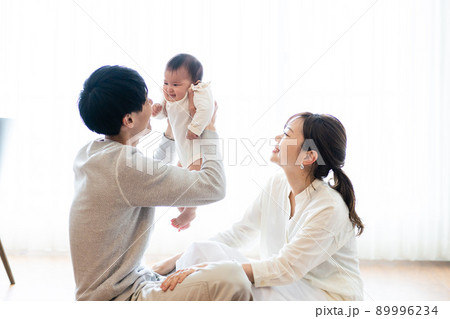 赤ちゃんを抱き上げるパパとママ 89996234