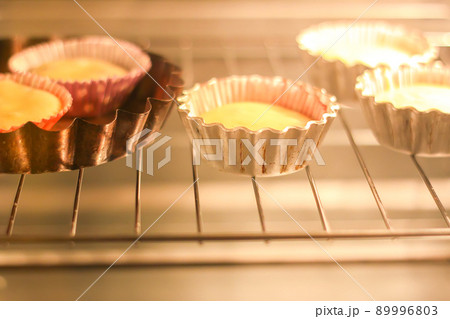 Homemade sweet muffin baking in a molds in oven Homemade sweet muffin baking in a molds in oven 89996803