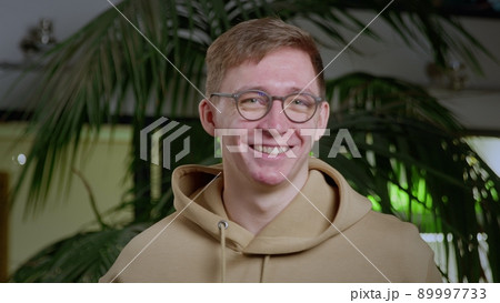 Close-up of a young man with pimples on his face. Guy guy puts on glasses. Close-up of a young man with pimples on his face. Guy guy puts on glasses. 89997733