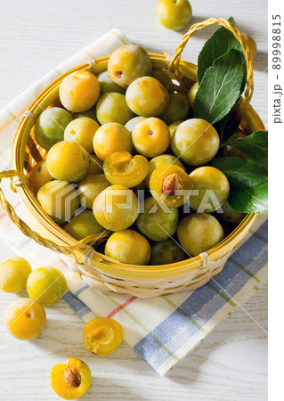 Berries yellow plums on a white wooden table 89998815
